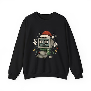 May include: Black sweatshirt featuring a cartoon computer character wearing a Santa hat, glasses, and a green scarf. The computer is decorated with Christmas lights and snowflakes. The computer character is making a peace sign with its hands. The sweatshirt is a crew neck.