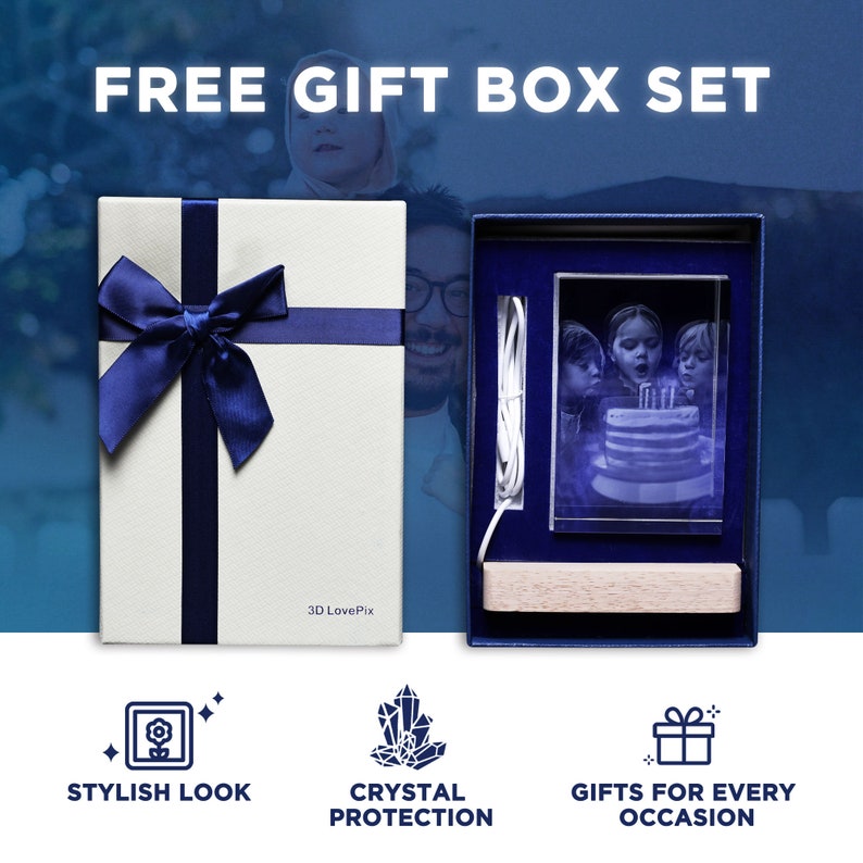 Puede incluir: Una caja de regalo blanca con cinta y lazo azul oscuro, que contiene un bloque de vidrio rectangular con una imagen grabada con l&aacute;ser en 3D de ni&ntilde;os soplando velas de cumplea&ntilde;os, una base de madera clara y un cable de alimentaci&oacute;n blanco, con la etiqueta 3D LovePix.