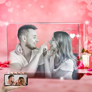 May include: A crystal cube with a black and white photo of a couple inside. The photo shows the couple looking at each other and smiling. The text "Love you" is written on the cube, with a white heart next to it.