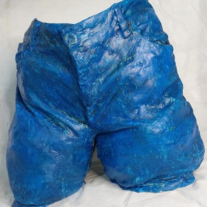 Op de afbeelding: Een blauwe denim-achtige sculptuur van een short.