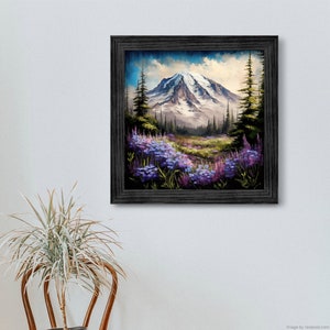 Könnte beinhalten: Ein gerahmtes Gemälde einer Berglandschaft mit einem schneebedeckten Gipfel, üppigen grünen Bäumen und einem Feld mit violetten Wildblumen.