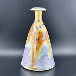 May include: A ceramic vase with a wide, flared base and a narrow neck. The vase is decorated with a colorful glaze that features shades of purple, blue, yellow, and brown.