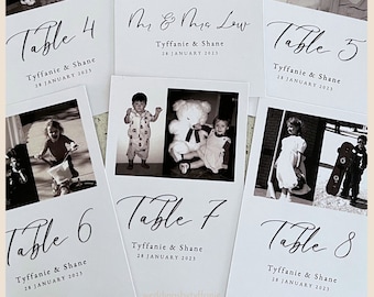 May include: A collection of white rectangular table number cards featuring black text and monochromatic photographs. Each card displays a table number, the names Tyffanie & Shane, and the date 28 January 2023. The cards showcase various personal photos.