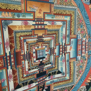 May include: A colorful mandala with intricate geometric patterns and symbols. The mandala is surrounded by a blue border with waves and a red border with a wheel.