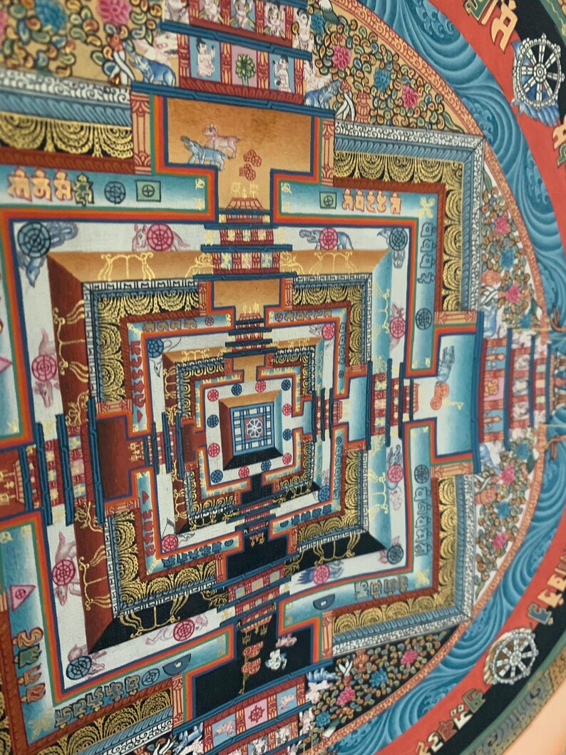 May include: A colorful mandala with intricate geometric patterns and symbols. The mandala is surrounded by a blue border with waves and a red border with a wheel.