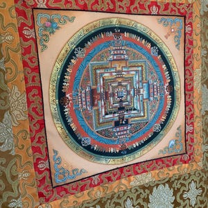 May include: A colorful mandala tapestry with a gold border and intricate details. The mandala is surrounded by a red, orange, and gold border. The tapestry is made of silk and is perfect for adding a touch of spirituality to any room.