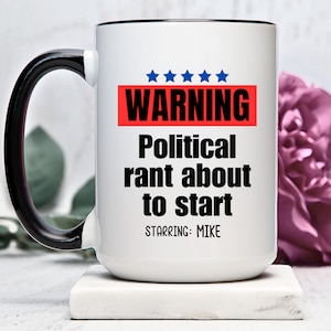 May include: White ceramic mug with a black handle. The mug has a red and black warning sign that says "WARNING Political rant about to start starring: MIKE".