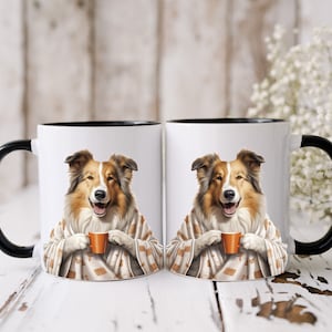 May include: Two white ceramic mugs with black handles and black rims. Each mug features a brown and white Collie dog wearing a brown and white blanket and holding a small orange mug.