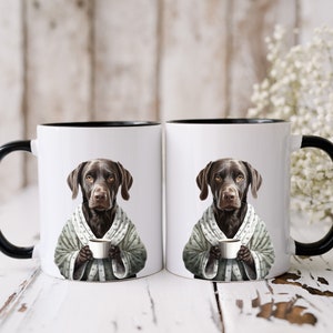 May include: Two white ceramic mugs with black rims, each featuring a brown dog wearing a gray and white robe and holding a cup of coffee.