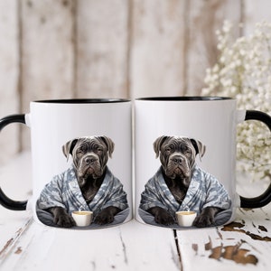 May include: Two white coffee mugs with black rims. Each mug features a black Cane Corso dog wearing a blue and white patterned robe and holding a small cup of coffee.