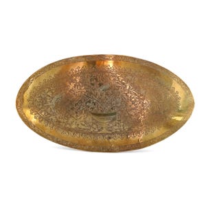 May include: An oval brass tray featuring an intricate etched design of a central urn filled with floral arrangements. The surface is decorated with detailed leaf patterns and a decorative border that follows the curved edge of the metal tray.