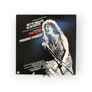 Peut inclure: Une pochette d'album noir et blanc pour la bande originale du film "The Rose". La pochette présente une photo de Bette Midler chantant dans un microphone. Le texte sur la pochette indique "The Original Soundtrack Recording", "Bette Midler", "Alan Bates", "A Marvin Worth Aaron Russo Production", "A Mark Rydell Film", "The Rose", "Also Starring", "Frederic Forrest", "Produced by Marvin Worth & Aaron Russo", "Directed by Mark Rydell", "Screenplay by Bill Kerby and Bo Goldman", "Story by Bill Kerby", "Executive Producer Tony Ray", "Director of Photography Vemos Mong ASC".