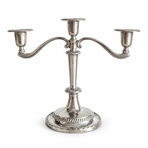 May include: A silver-toned metal candelabra featuring three candle holders with a central stem and two curved arms. The base, stem, and candle cups are decorated with a rope-like textured border detail. The finish is smooth and reflective.