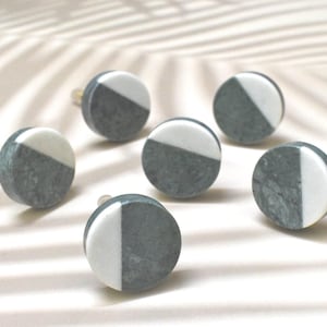 Könnte beinhalten: Sechs runde, graue und weiße Marmorknopfknöpfe mit goldener Beschläge.