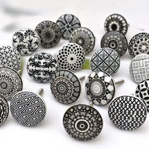 Puede incluir: Una colección de 18 pomos de armario de cerámica en blanco y negro con varios patrones geométricos y florales.