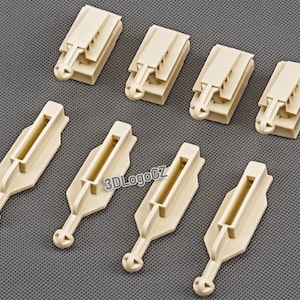 Peut inclure: Huit clips en plastique beige pour usage automobile. Les clips ont différentes formes et tailles, certains ayant une forme de crochet et d'autres une forme plus rectangulaire.