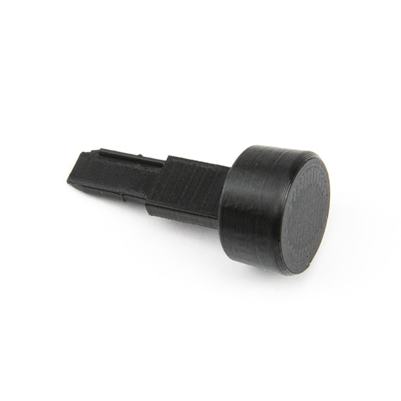 May include: A black plastic tool with a flat, pointed tip and a round, black knob on the other end.