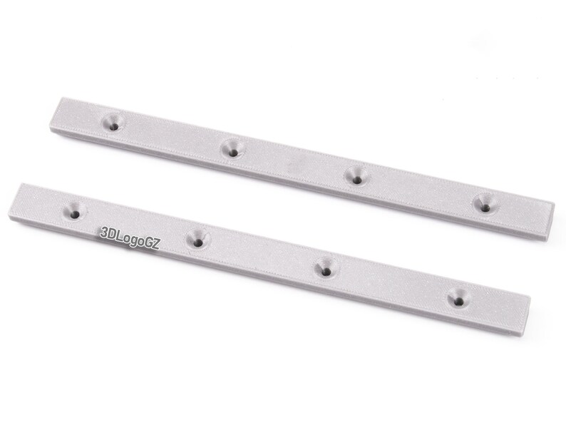 Pode incluir: Duas barras de metal prateadas, retangulares, com v&aacute;rios orif&iacute;cios espa&ccedil;ados uniformemente. As barras t&ecirc;m uma superf&iacute;cie texturizada e est&atilde;o dispostas diagonalmente. O texto "3DLogoGZ" &eacute; vis&iacute;vel numa barra.