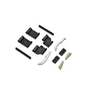 Op de afbeelding: Een assortiment zwarte en gebroken witte kunststof componenten, waaronder rechthoekige clips, gebogen stukken en kleine, schuine onderdelen. De items zijn gerangschikt op een witte achtergrond, wat wijst op een productdisplay of onderdelenset.