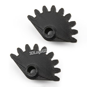 Op de afbeelding: Twee zwarte kunststof tandwielen met elk 12 tanden. De tandwielen zijn halfrond en hebben een klein gat in het midden.