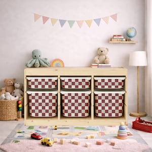 Könnte beinhalten: Ein Holz-Aufbewahrungseinheit mit sechs karierten Behältern in Burgunderrot und Creme. Die Einheit befindet sich in einem Kinderzimmer, mit Spielzeug und einer bunten Girlande im Hintergrund. Die Behälter sind ideal zum Ordnen von Spielzeug.