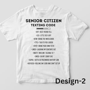 Puede incluir: Camiseta blanca con texto negro: "SENIOR CITIZEN TEXTING CODE" y una lista de acrónimos de mensajes de texto. La camiseta incluye el texto "Design-2" en la parte inferior. Una idea de regalo humorística.