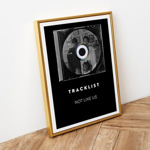 Könnte beinhalten: Ein Schwarzweißfoto einer Familie ist auf einer CD in einem goldenen Rahmen gedruckt. Der Text "TRACKLIST" und "NOT LIKE US" ist unter der CD gedruckt.