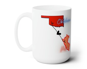 May include: White ceramic mug with a red outline of the state of Oklahoma and a peach outline of Peru. The outlines are connected by a black line with a heart in the middle. The text "Oklahoma" is in blue and the text "Peru" is in pink.