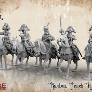 Op de afbeelding: Zes grijze plastic miniatuurfiguren van Franse hoge commandanten uit de Napoleontische tijd te paard. De figuren zijn in verschillende houdingen geposeerd en houden zwaarden en andere wapens vast. De figuren zijn gemonteerd op paarden met gedetailleerde zadels en teugels. De figuren maken deel uit van de Horse and Musket-lijn van miniaturen van Battle Cat Miniatures.
