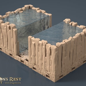 Peut inclure: Modèle miniature d'une piscine à murs de pierre avec un élément d'eau bleu clair. La piscine est divisée en deux sections, avec un petit espace entre elles. Le modèle est fait d'un matériau brun clair et a une surface texturée.