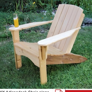 Puede incluir: Silla Adirondack de madera natural con un portavasos en el reposabrazos. La silla está sentada en un césped. Planes de silla Adirondack de bricolaje. PDF digital. Descargar.