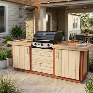 Peut inclure: Un barbecue à gaz noir avec trois boutons argentés est intégré dans un îlot de cuisine d'extérieur en bois. L'îlot présente des panneaux de bois verticaux clairs, un cadre brun rougeâtre et deux placards avec des poignées argentées.