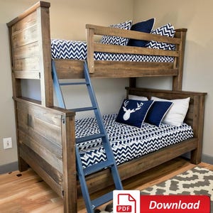 May include: A wooden bunk bed with a blue ladder. The top bunk has a white and blue chevron patterned bedding and the bottom bunk has a white and blue chevron patterned bedding with a white deer head pillow.