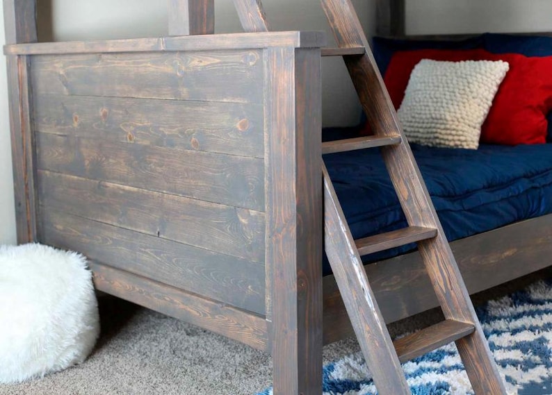 May include: A wooden bunk bed frame with a ladder. The frame is stained a dark brown color and has a rustic look. The ladder is made of the same wood and has four steps.