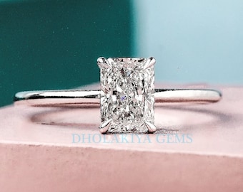 May include: A silver engagement ring with a large, clear, rectangular-shaped diamond.
