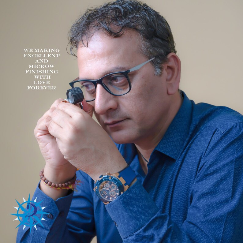 May include: A man wearing glasses and a blue shirt examines a piece of jewelry with a magnifying glass. The text "WE MAKING EXCELLENT AND MICROW FINISHING WITH LOVE FOREVER" is visible in the image.