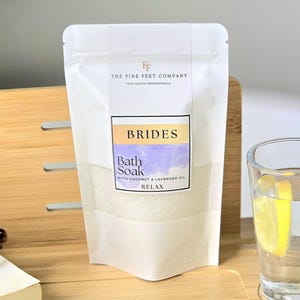Peut inclure: Pochette blanche avec une étiquette qui dit "BRIDES Bath Soak with Coconut & Lavender Oil RELAX" et le texte "FF THE FINE FEET COMPANY FOOT HEALTH PROFESSIONALS" au-dessus de l'étiquette.