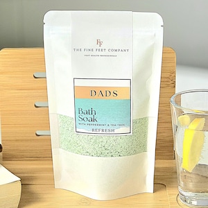 Peut inclure: Pochette blanche avec une étiquette indiquant "DADS Bath Soak with Peppermint & Tea Tree REFRESH" et le logo "FF THE FINE FEET COMPANY FOOT HEALTH PROFESSIONALS".