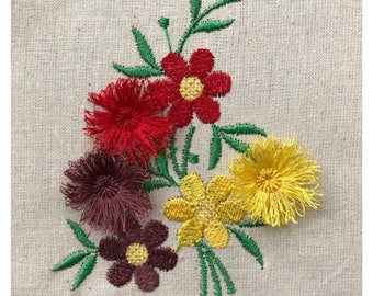 May include: Embroidered floral design featuring red, yellow, and brown flowers with green leaves on a beige fabric background.