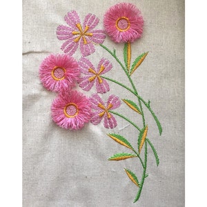 May include: Embroidered pink flowers with green stems and yellow leaves on a white linen fabric.