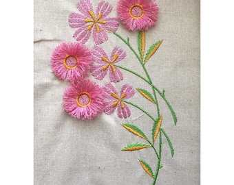 May include: Embroidered pink flowers with green stems and yellow leaves on a white linen fabric.