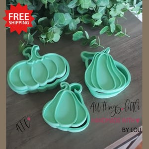 May include: Three light green pumpkin-shaped cookie cutters. The cutters are made of plastic and have a layered design. The image also includes the text "All things little handmade with love by Lou".