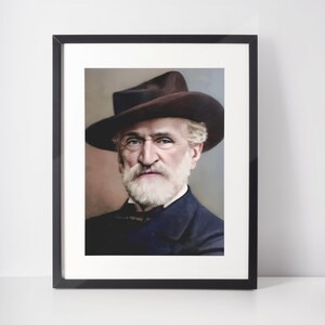 Könnte beinhalten: Ein Schwarzweißporträt eines Mannes mit weißem Bart, der einen braunen Hut trägt. Der Mann blickt direkt in die Kamera.