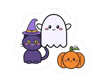 May include: A die-cut sticker featuring a purple cat wearing a pointed witch hat, a white ghost with a smiling face, and an orange pumpkin with a green stem. Each character has a simple, cartoon-style design with rosy pink cheeks and black eyes.