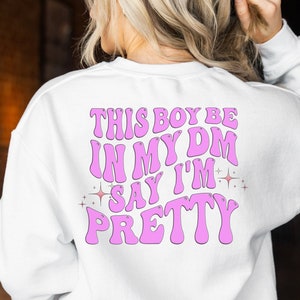 May include: White sweatshirt with pink text that reads "This boy be in my DM say I'm pretty" with pink glitter stars on either side of the text.