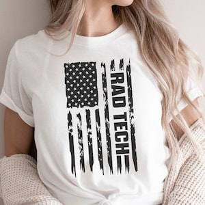 May include: White t-shirt with a distressed American flag design and the text "RAD TECH" printed vertically on the right side of the flag.