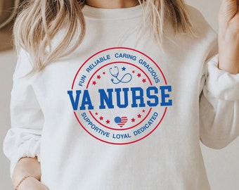 Könnte beinhalten: Weißer Pullover mit einem blauen und roten Kreis-Motiv, auf dem "VA NURSE" mit Sternen und den Worten "Fun, Reliable, Caring, Gracious, Supportive, Loyal, Dedicated" steht.