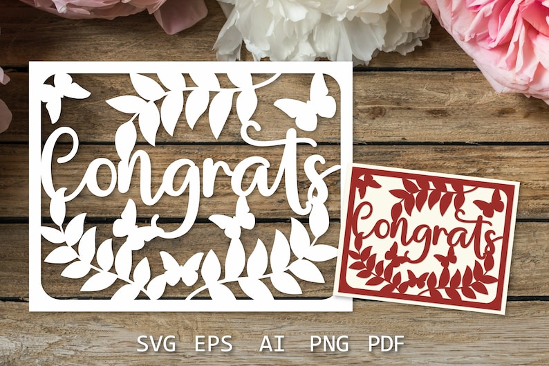 以下が含まれることがあります： 木製の背景に白い紙で切り抜かれた「Congrats」の文字と葉と蝶の模様。クリーム色の背景に赤い紙で切り抜かれた「Congrats」の文字と葉と蝶の模様。