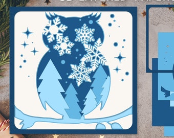 May include: A 3D layered papercraft design featuring a blue owl with snowflakes and pine trees. The design is titled "3D Layered Papercraft".