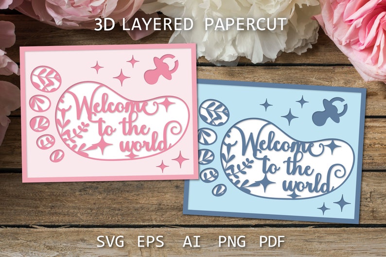 May include: Two 3D layered papercut cards with a baby footprint design. The card on the left is pink and the card on the right is blue. Both cards feature the text "Welcome to the world" and a pacifier.